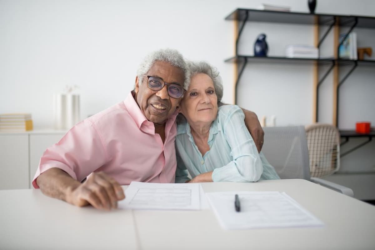 An older couple going over their home paperwork together at the kitchen table